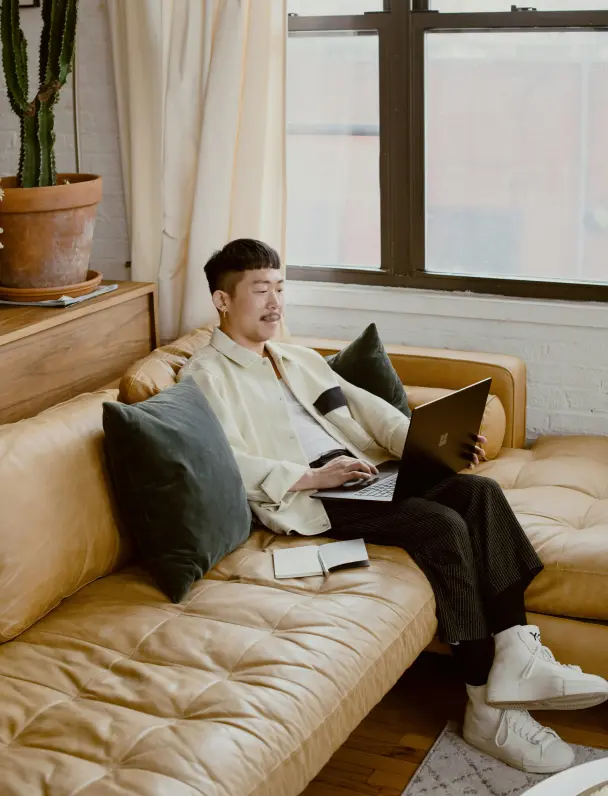 Professional working on a laptop in a home office with plants